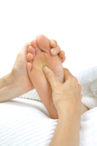 Foot reflexology, a thumb is applying pressure to the sole of a foot